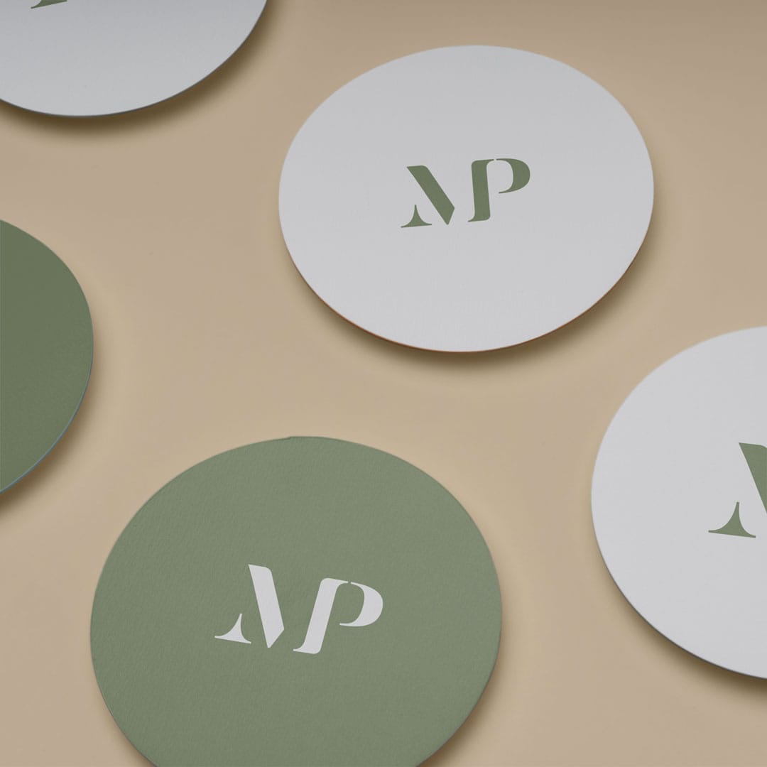 A set of green and white coasters with the branding "mp" on them.